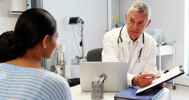 Doctor speaking with female patient, offering medical advice and discussing diagnosis in a professional office environment. Perfect for healthcare websites, medical articles, patient education materials, and healthcare advertisements.