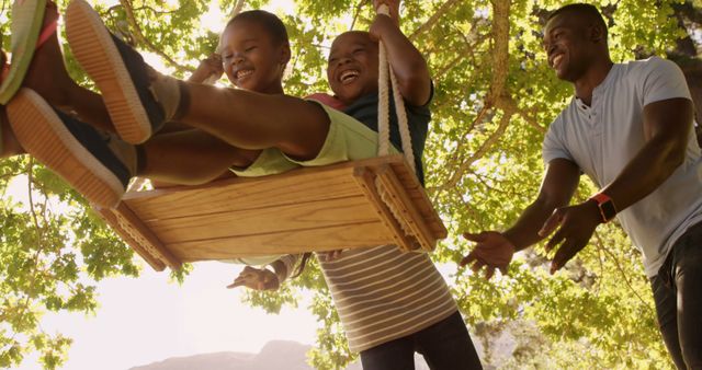 Father Pushing Children on Swing in Sunny Park - Download Free Stock Images Pikwizard.com