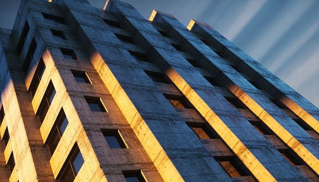 Brutalist concrete tower catching diagonal golden sunlight with recessed windows