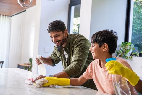 Father and son teaming up for kitchen cleaning chore