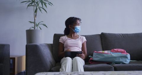 Girl Wearing Mask Sitting on Couch in Medical Facility with Tablet - Download Free Stock Images Pikwizard.com