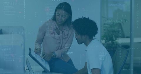 Diverse team collaborating over computer code in modern office
