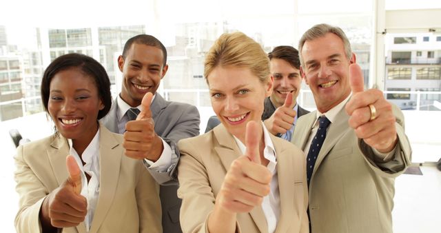 Business people giving thumbs up at the office