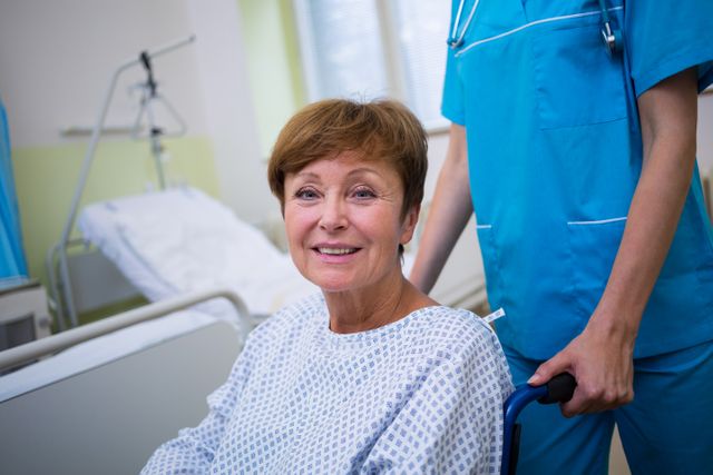 Nurse assisting a smiling patient in a wheelchair in a hospital room. Ideal for use in healthcare, medical, and patient care-related content, showcasing support and recovery in a hospital setting.