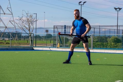 Male field hockey player in ready stance on synthetic turf