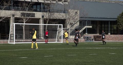 Youth soccer players celebrating goal on school field