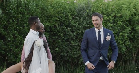 Joyful wedding guests celebrating outdoors with lush greenery