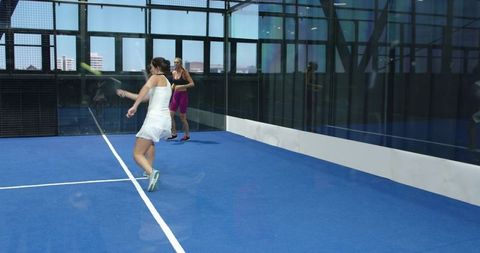Two Female Friends Playing Padel on Modern Urban Court