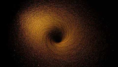 Golden particle vortex spiraling into dark core, hypnotic abstract swirl with cosmic depth