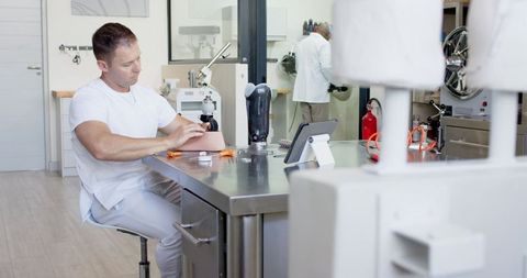 Prosthetic technician using lathe in modern workshop