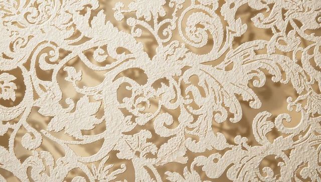 Ivory embossed damask scrollwork on gold satin backing with soft shadowed relief