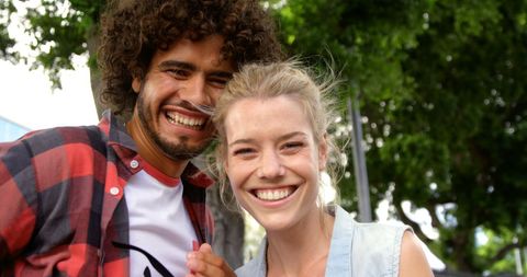 Cheerful Friends Embracing in Sunny Urban Park