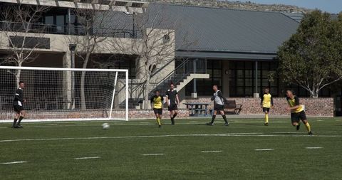 Soccer players in yellow ready for penalty kick on outdoor field