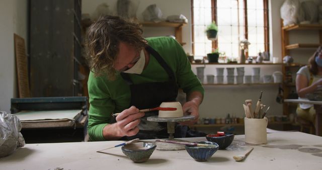 Potter painting ceramic bowl in art studio - Download Free Stock Images Pikwizard.com