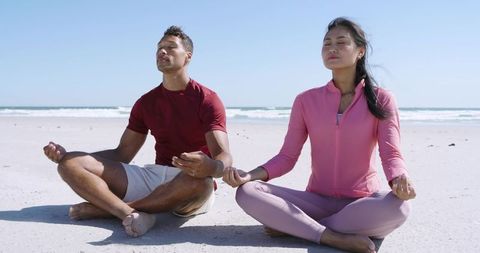Asian Woman and Man Meditating on Beach Practicing Mindfulness Yoga by Ocean Waves Wellness
