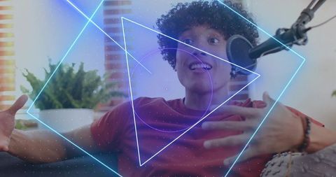 Young man recording podcast on sofa with neon geometric overlay and condenser mic