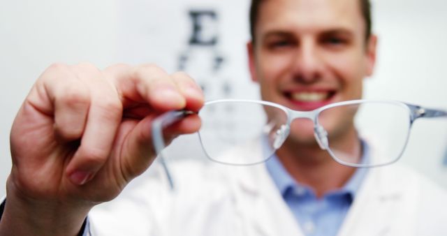 Optometrist Holding Glasses towards Camera in Optical Clinic - Download Free Stock Images Pikwizard.com