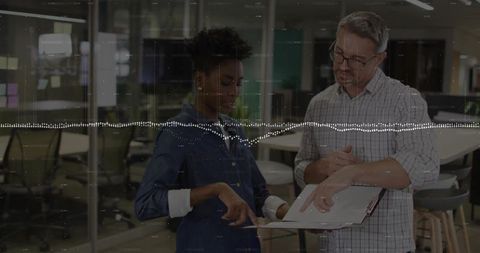 Colleagues Analyzing Documents in Modern Office Environment