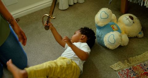 Child Engaged in Play with Toy Sword in Living Room