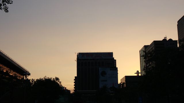 Silhouetted Urban Skyline at Dusk with Soft Golden Sky - Download Free Stock Photos Pikwizard.com