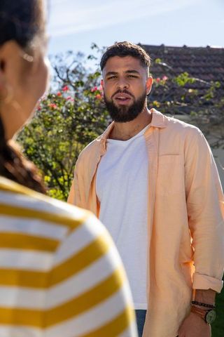 Friends interacting outdoors amid sunlit garden