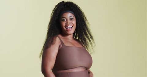 Confident Woman in Brown Sportswear Expressing Joy and Fitness