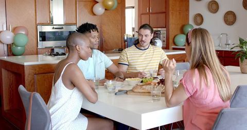 Friends Enjoying Meal and Conversation Around Dining Table