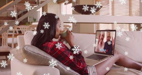 Woman Sharing Festive Moments on Video Call with Snow Overlay