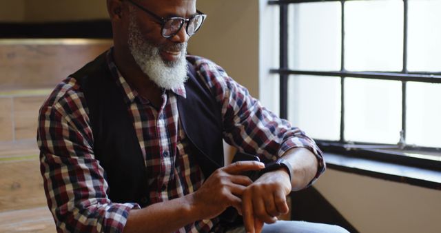 Smiling Elderly Man Using Smartwatch Indoors - Download Free Stock Images Pikwizard.com