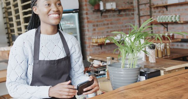 Smiling Female Barista Using Smartphone in Modern Cafe - Download Free Stock Images Pikwizard.com