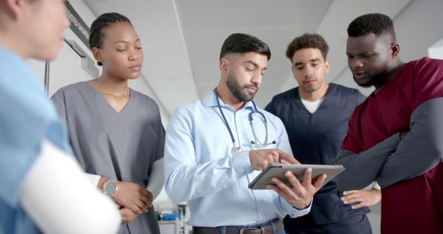 Doctors and medical students discussing patient diagnosis on tablet in hospital - Download Free Stock Images Pikwizard.com