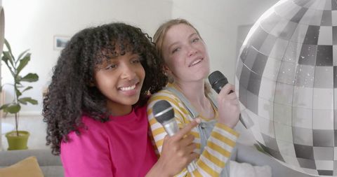 Teenagers enjoying karaoke with mirror ball at home