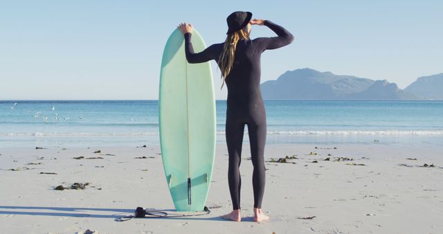 Surfer in Black Wetsuit Holding Board on Sandy Beach - Download Free Stock Images Pikwizard.com