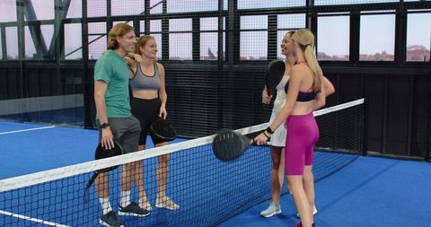 Friends Playing Padel Discussing Match Strategy on Blue Court