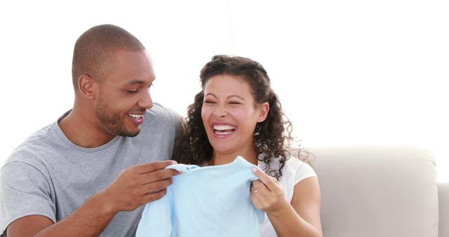 Happy Expectant Couple Preparing Baby Clothes - Download Free Stock Images Pikwizard.com