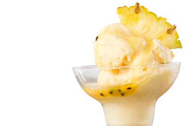 This image features a delicious serving of pineapple ice cream in a glass cup, garnished with a fresh pineapple wedge. Ideal for use in food blogs, summer-themed promotions, dessert menus, and advertisements for tropical or exotic flavors.