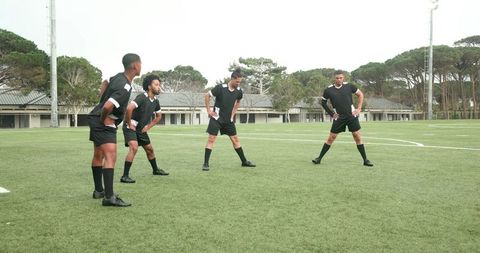 Soccer Players Warm Up Before Practice on Green Field