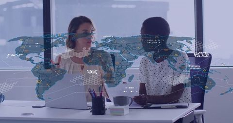 Businesswomen Collaborating in Modern Office with Global Data Overlay