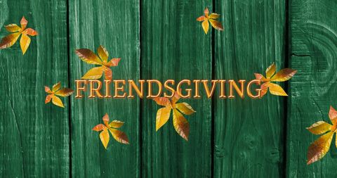 Friendsgiving Text on Green Wood with Autumn Leaves Background