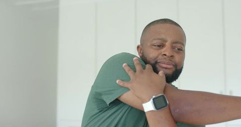 Bearded african american man reacting as partner pressing arm across chest showing unease