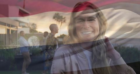 Smiling woman outdoors at sunset with palm trees in background