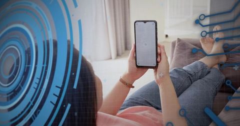 Asian woman using smartphone on sofa with augmented reality HUD overlay for app mockup