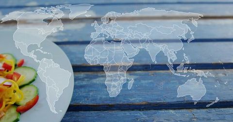 Global food journey on rustic blue tabletop with fresh salad and world map overlay