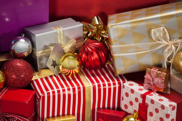 Close-up of beautifully wrapped gift boxes and colorful baubles, perfect for holiday season promotions, festive greeting cards, Christmas advertisements, and seasonal blog posts. The vibrant colors and intricate wrapping make it ideal for conveying the joy and excitement of Christmas celebrations.