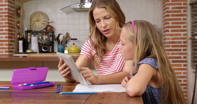 Mother and Daughter Using Tablet for Homework in Kitchen - Download Free Stock Images Pikwizard.com