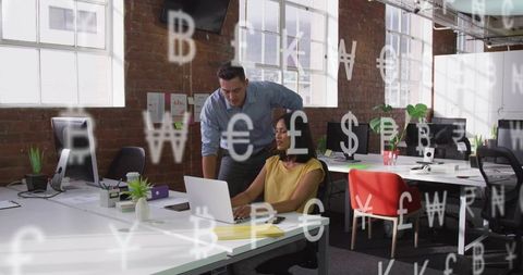 Man pointing at laptop while woman typing in modern coworking space with currency overlay
