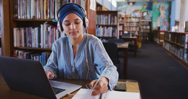 Focused Student Studying in Library with Laptop and Headphones - Download Free Stock Images Pikwizard.com