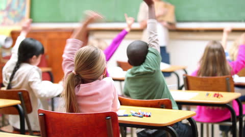 Engaged Elementary Students Raising Hands in Classroom