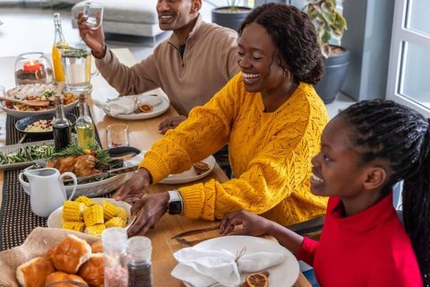 African american family sharing joyful holiday meal at sunlit wooden dining table