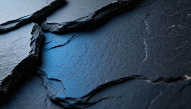 Macro Slate Revealing Layered Jagged Fissures with Blue Highlight for Dark Texture
